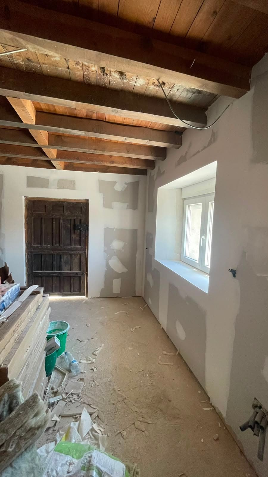 Trasdosado de pladur alrededor de ventana en vivienda con vigas