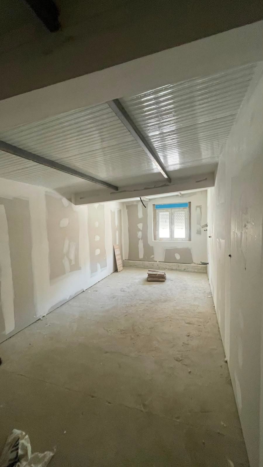 Tabiques y trasdosados de pladur en una estancia larga en obra